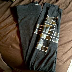 Gray yoga pants with camo detail on pant legs. Pink logo on the side.